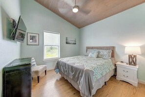 A bedroom with a bed, a nightstand, a dresser, a window with blinds, and a ceiling fan. - Eskridge Gem Unit B - Near Shops & Beach, Dogs OK (Port Aransas)