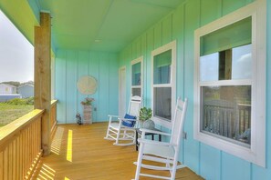 A porch with wooden railings, white rocking chairs, and a potted plant. - LandsEnd - Indoor-Outdoor Living, Boat Parking (Rockport)