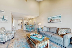 A living room with a sofa, armchairs, a coffee table, and a rug. There is a dining area with chairs and a table in the background. - Belle of the Bay - Boat Slip, Pool & Tennis (Rockport)