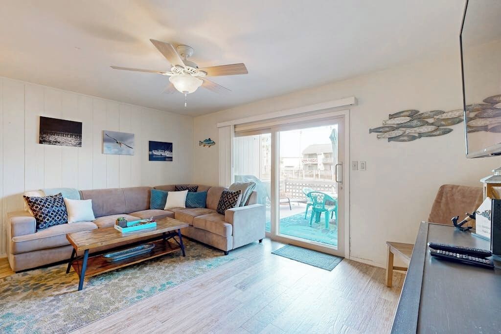 A living room with a sofa, coffee table, and a ceiling fan.