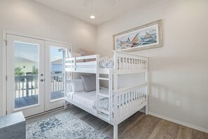 A bunk bed with a view of the outdoors through a sliding door. - Barnacle Bay - Pool Access, Deck & EV Charger (Rockport)