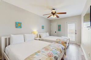 A hotel room with two beds, a ceiling fan, and artwork on the walls. - Cay Getaway - Private Balcony & Shared Pool (Corpus Christi)