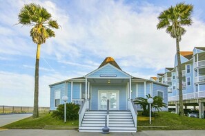 A two-story building with a blue exterior, a front porch, and a sign that reads 'Hotel Registration.' - Seascape #2319 Beach Happy (Galveston)