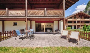 A wooden building with a balcony, outdoor seating, and a view of a mountain. - ELEGANT CHALET APARTMENT IN THE HEART OF LAUTERBRUNNEN (Lauterbrunnen)