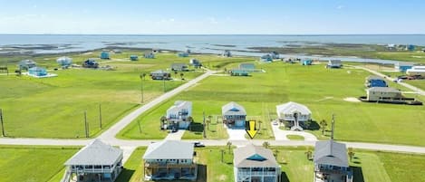Bairro residencial com várias casas, algumas com garagens anexas, e vista aberta para a paisagem ao redor.