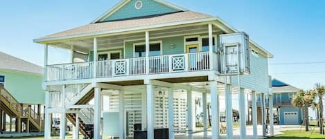 A two-story house with a balcony, a covered porch, and a garage.