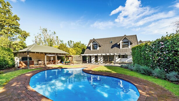 A residential property with a swimming pool, a covered patio, and a large house with a sloped roof. - Hawkings Lodge - Kerikeri Holiday home (Kerikeri)