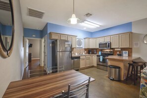 A modern kitchen with a central island, stainless steel appliances, and light blue walls. - Palm Bay 305 - Lagoon Pool, Patio & Dogs OK (Corpus Christi)
