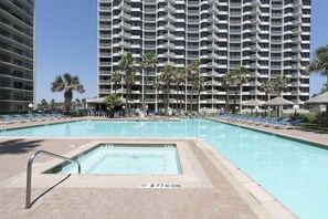 A swimming pool with a 3 ft depth limit, surrounded by lounge chairs and palm trees, with a high-rise hotel in the background. - Saida Towers IV #602 (South Padre Island)