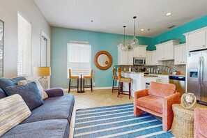 A modern living room with a sofa, a coffee table, and a striped rug. - Campeche Retreat #2 - Gulf Views, Pool & Sundeck (South Padre Island)