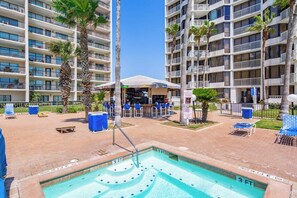 A hotel pool area with a 3 FT depth marker, surrounded by palm trees and lounge chairs. - Saida Towers IV #4802 (South Padre Island)