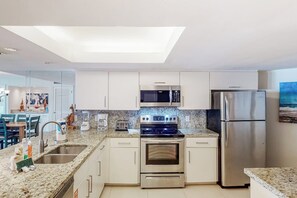 Eine moderne Küche mit Oberlicht, Edelstahlgeräten und einer Arbeitsplatte aus Granit.