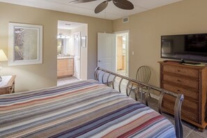 Ein Schlafzimmer mit Bett, Fernseher, Kommode und Stuhl.