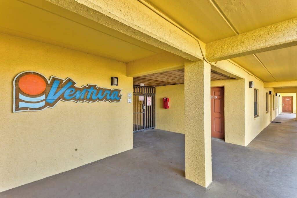 A corridor with a sign reading 'Ventura' and a fire extinguisher mounted on the wall.