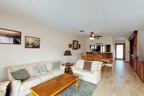 Un salon comprenant un canapé, une table basse et un coin repas avec des chaises.