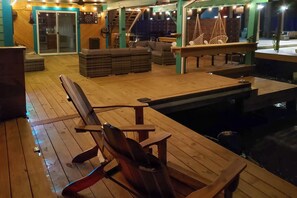 Eine Holzterrasse mit Pool, Sitzgelegenheiten und einer Treppe zu einer erhöhten Ebene.