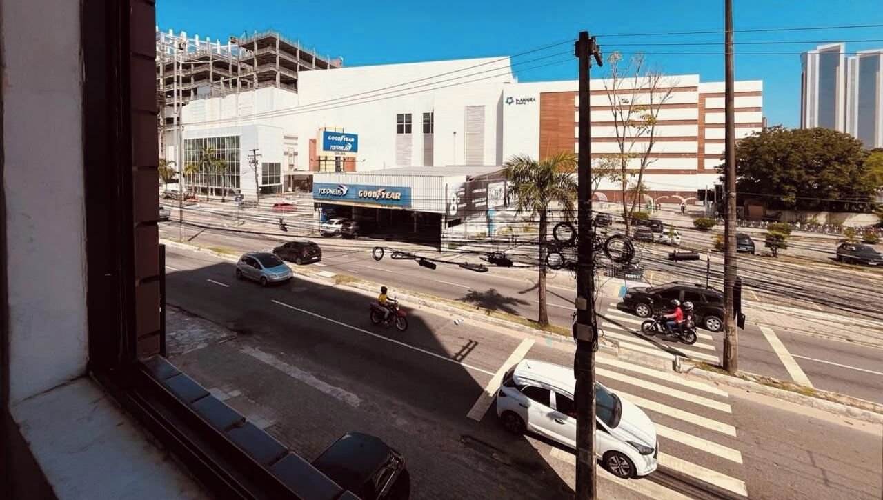 Vista de la calle con una tienda Goodyear de neumáticos, un paso de peatones y un edificio en construcción.