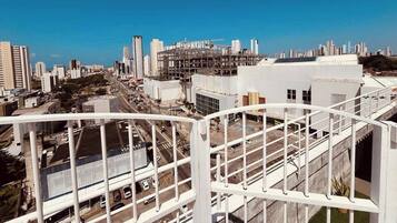 Um edifício alto com vista para o horizonte urbano, incluindo uma ponte e um estacionamento.