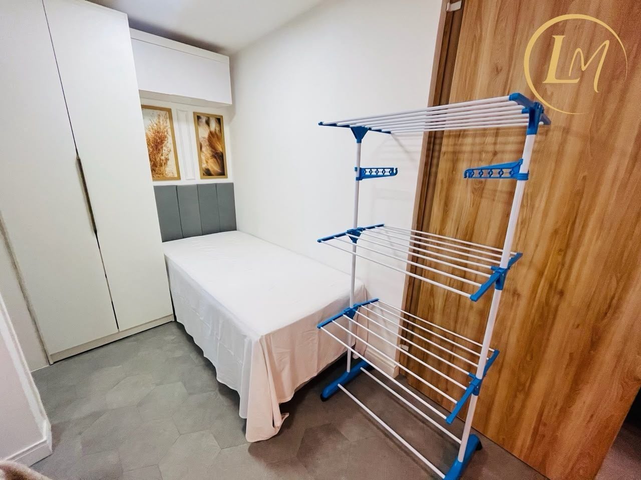 Un dormitorio con una cama, un tendedero y un armario.