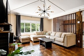 A modern living room with a sectional sofa, a coffee table, and a fireplace.