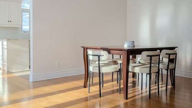 A dining area with a wooden table and four chairs, a white ceiling, and a wooden floor. - Villa Belvédère |Vue panoramique et Nature ! (Grenville-Sur-La-Rouge)