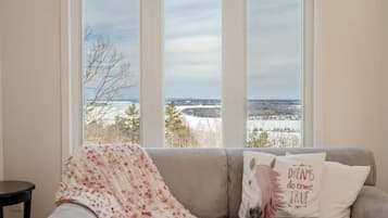 Ett rum med utsikt över ett snötäckt landskap genom tre fönster.