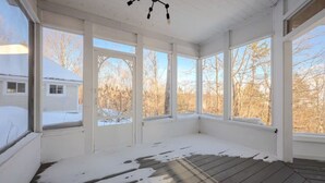 A room with large windows, a wooden floor, and a ceiling fan. - Villa Belvédère |Vue panoramique et Nature ! (Grenville-Sur-La-Rouge)