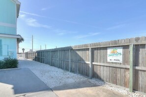 A wooden fence with a sign indicating a pool direction at Nemo Resort. - Nemo Cay - Nautical Nemo Cay (Corpus Christi)