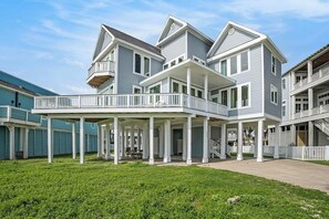 A multi-story residential building with a covered porch and multiple balconies. - Beach Haus - Ocean Views, Sleeps 22 & Bunk Room (Galveston)