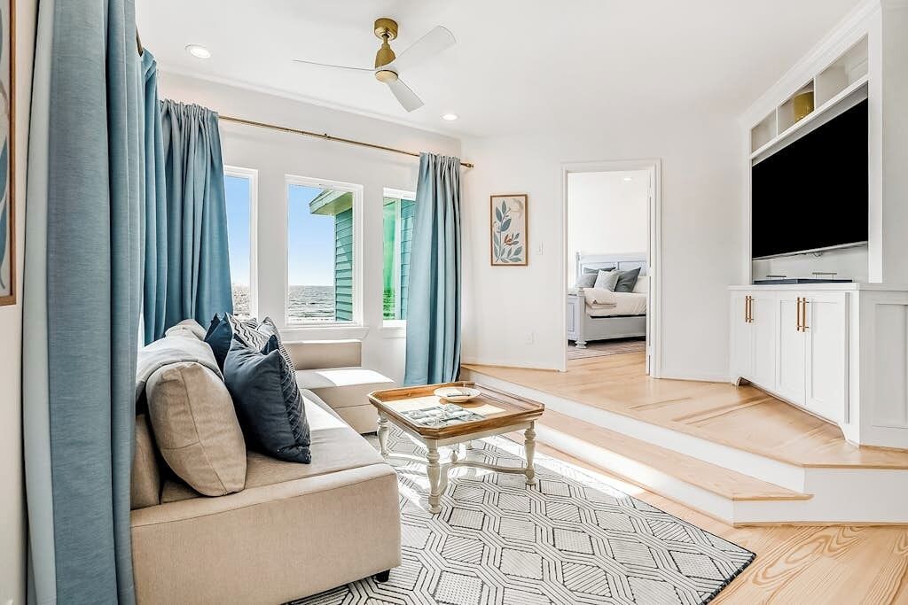 A modern living room with a sofa, coffee table, and a television.