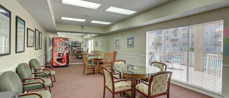 A hotel lobby with a reception desk, seating area, and large windows.