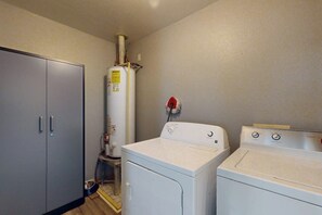 Ein Waschraum mit Waschmaschine, Trockner und Warmwasserbereiter.