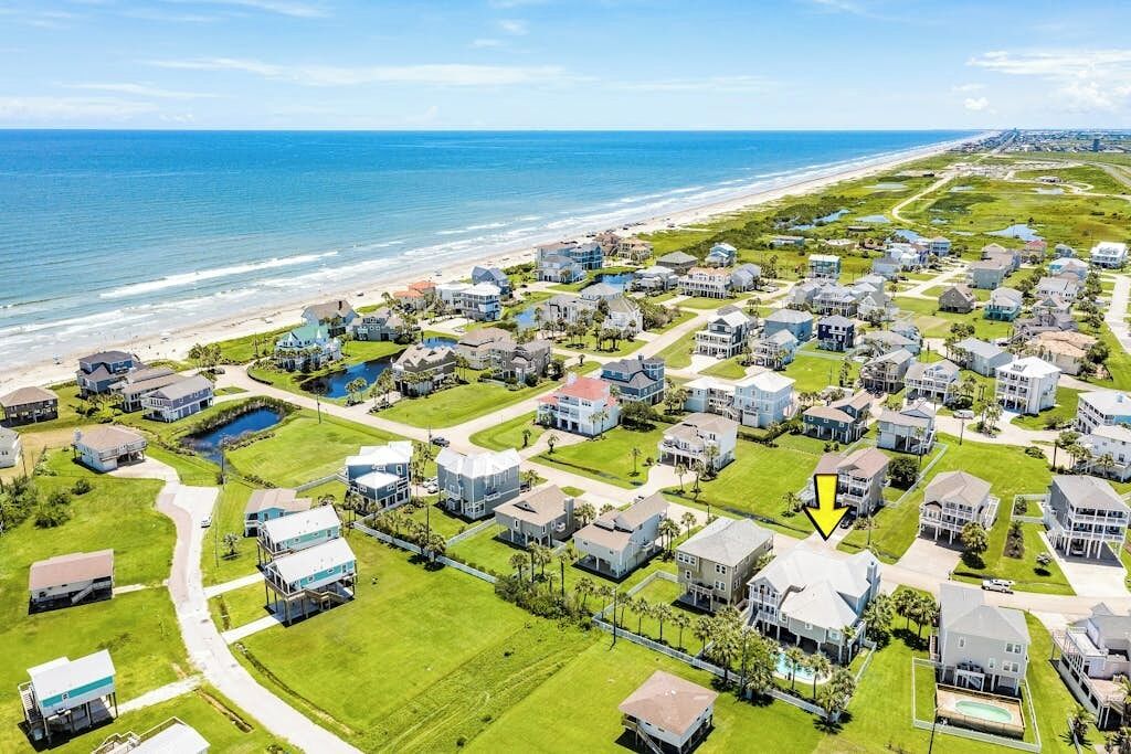 Zona residencial a la costa, amb cases, una platja i un camp de golf.