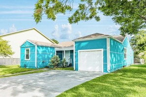 A two-story house with a garage, a front porch, and a well-maintained lawn. - The Seahorse - Sleeps 12, Near Beach & Downtown (Galveston)