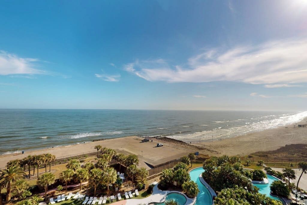 A resort with a swimming pool, beach access, and a view of the ocean.
