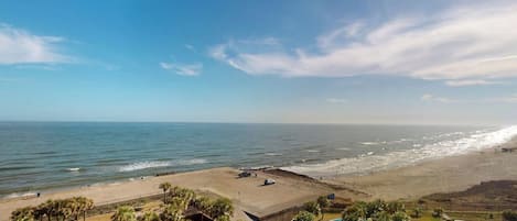 A resort with a swimming pool, beach access, and a view of the ocean.