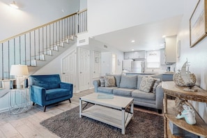 A spacious living area with a staircase, a kitchen, and a dining area. - Leeward Cove A8 - Pool & Hot Tub, Beach Nearby (Corpus Christi)