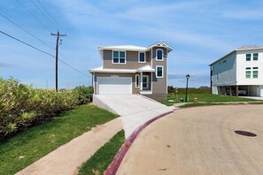 Ein zweistöckiges Wohnhaus mit Garage, Auffahrt und gepflegtem Rasen.