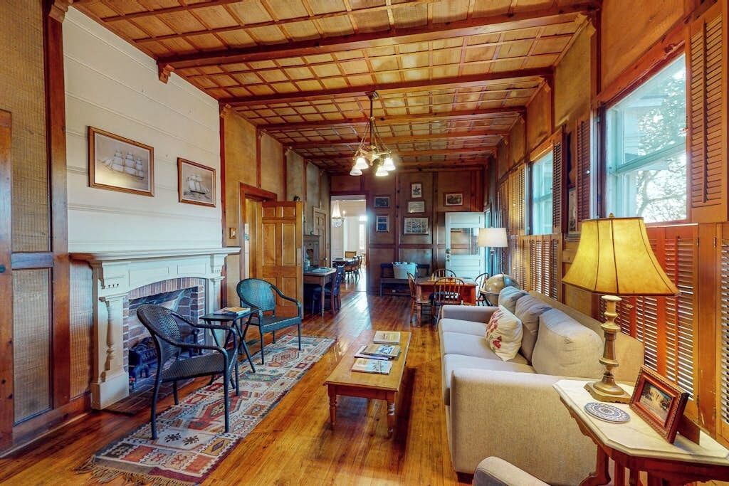 A spacious living room with a fireplace, wooden ceiling, and a sofa.