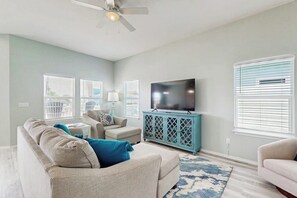 A living room with a sofa, a television, and a cabinet. - Ocean Breeze - Bay Views & Outdoor Kitchen (Rockport)