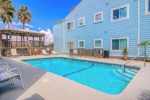 A swimming pool area with lounge chairs and a wooden deck. - Leeward Isles - Lyla's Beach Getaway (Corpus Christi)