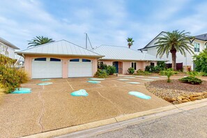 A residential driveway with a garage, a palm tree, and a well-maintained lawn. - Coral Cove - Waterfront with Amazing Views (Rockport)