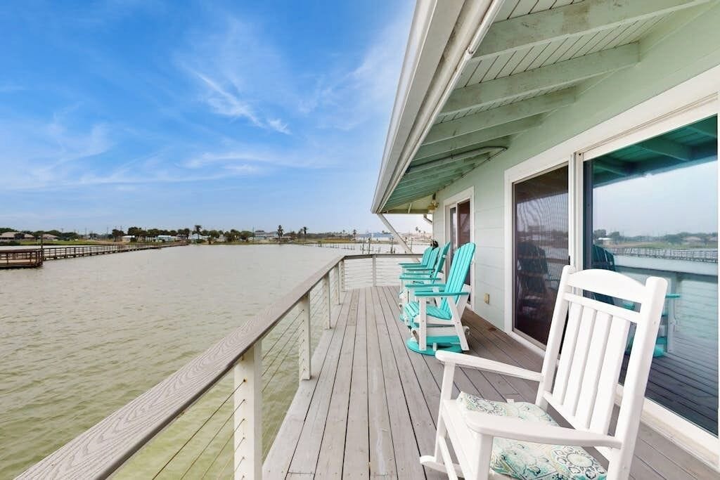 Eine Terrasse mit Stühlen und Blick auf das Wasser.