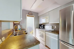 A kitchen with stainless steel appliances, a sink, and a countertop. - Puente Vista 133 - Bay-View Deck & Shared Pool (Corpus Christi)