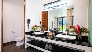Een moderne badkamer met twee wasbakken, een grote spiegel en een toilet.