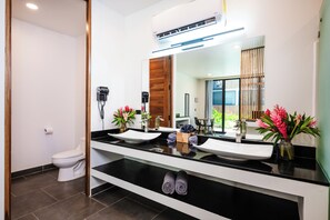 A modern bathroom with two sinks, a large mirror, and a toilet. - Luxury Nomad Containers (TAMARINDO)