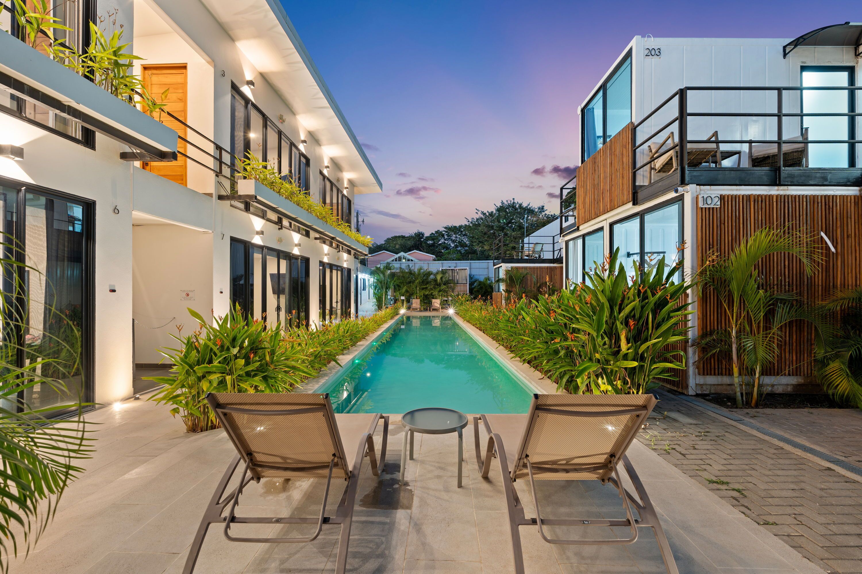 A modern outdoor pool area with lounge chairs and a clear view of the pool.
