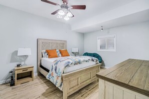 A bedroom with a bed, nightstands, a ceiling fan, and a window. - Bay Breeze Beauty - Waterfront, Hot Tub & Dogs OK (Rockport)