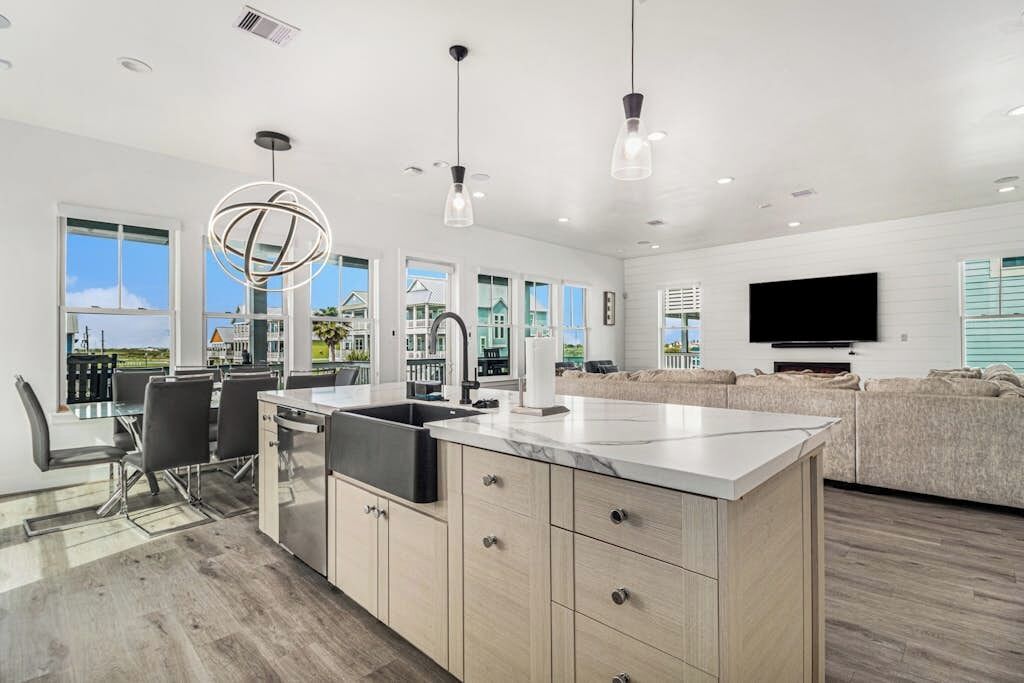 Una cocina moderna con una isla central, comedor y un ventanal con vistas.