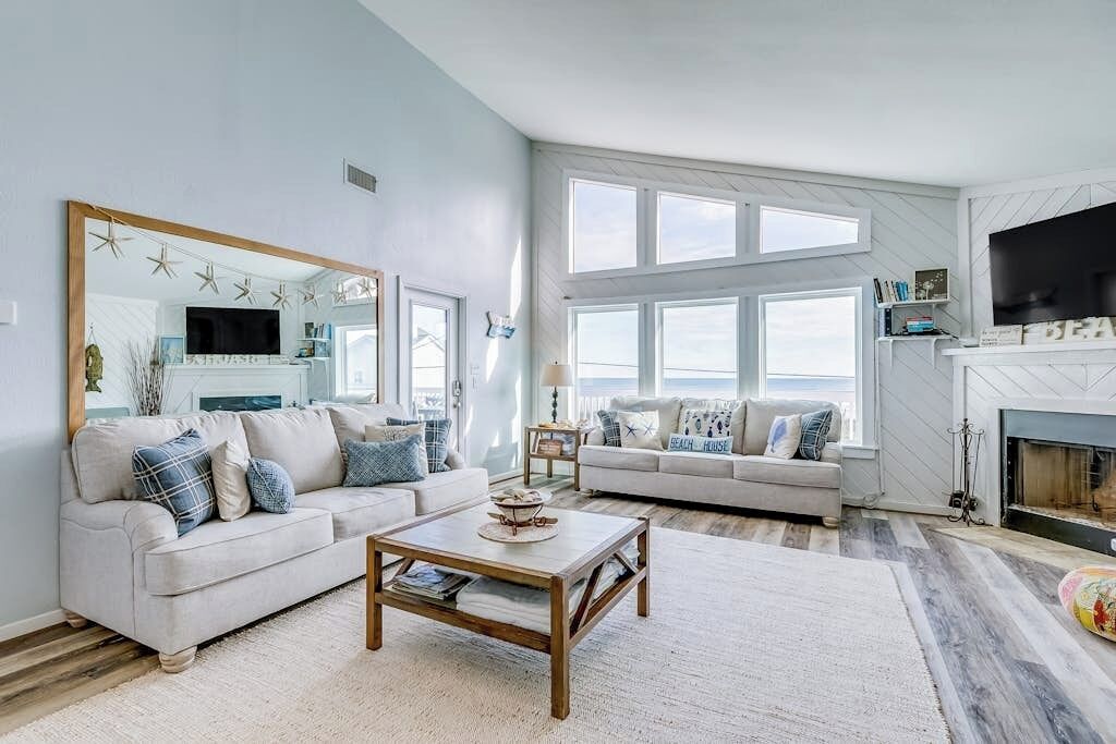 A living room with two sofas, a coffee table, and a fireplace.